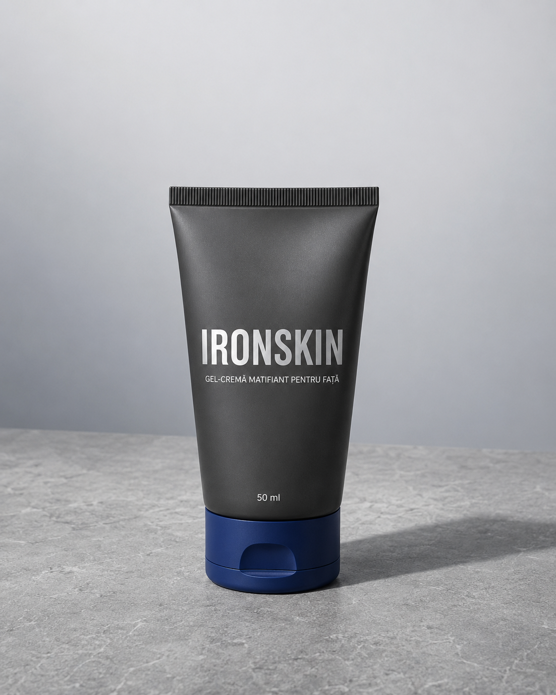 Flacon IRONSKIN gel-cremă matifiant 50 ml pe o suprafață de beton